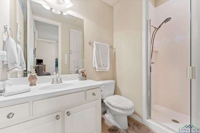 bathroom featuring vanity, a shower with shower door, and toilet