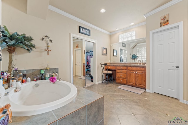 bathroom featuring vanity, a relaxing tiled tub, tile patterned floors, and ornamental molding