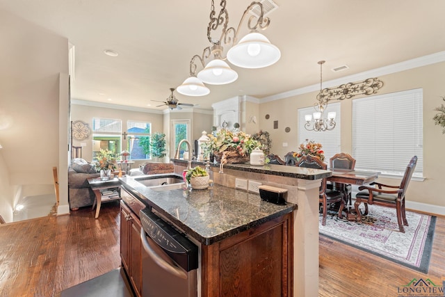 kitchen featuring dishwasher, sink, pendant lighting, a center island with sink, and ceiling fan with notable chandelier