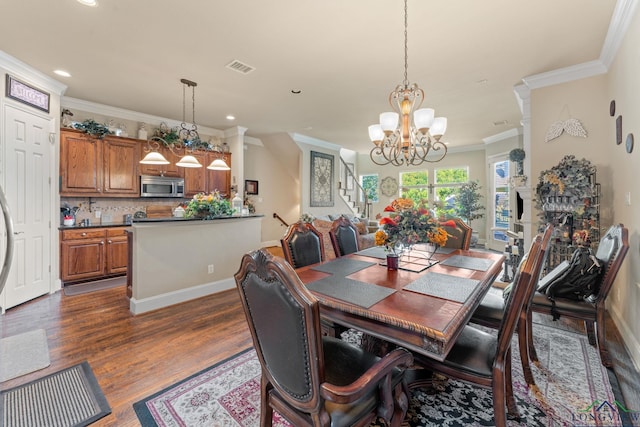 dining area with a fireplace, dark hardwood / wood-style flooring, crown molding, and a chandelier