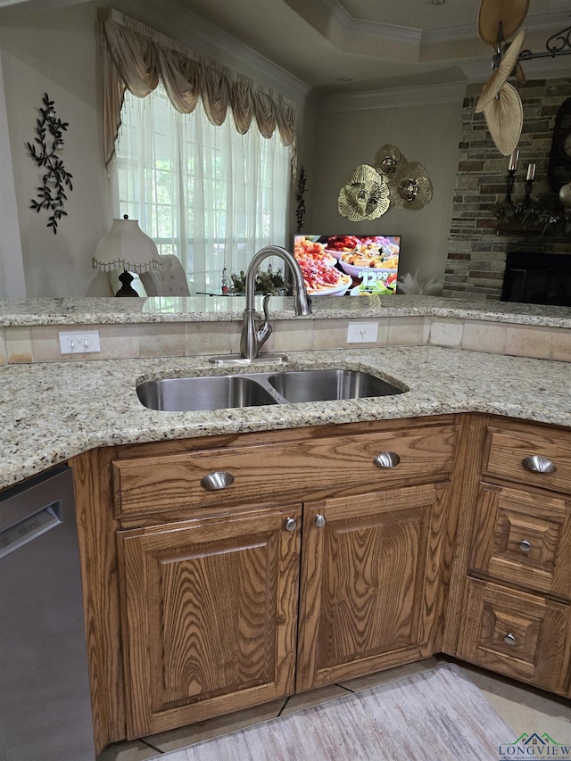 3720 Bill Owens Pkwy, Longview, TX 75605 - kitchen featuring dishwasher, brown cabinets, ornamental molding, light stone countertops, and light wood-style floors