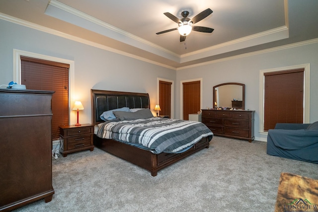 bedroom with crown molding, a tray ceiling, and ceiling fan