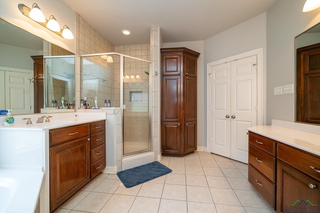 bathroom with an enclosed shower, vanity, and tile patterned flooring