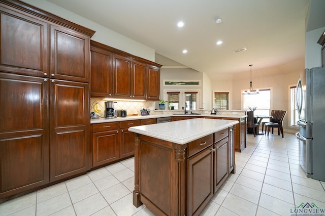 kitchen featuring sink, tasteful backsplash, decorative light fixtures, appliances with stainless steel finishes, and kitchen peninsula