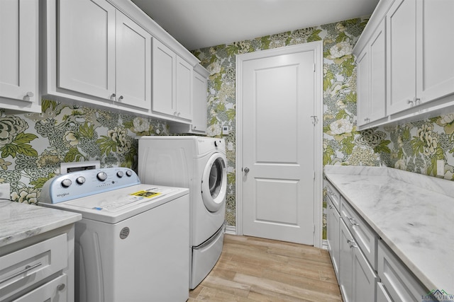 113 Saddle Brook Cir, Hallsville, TX 75650 - laundry room with wallpapered walls, cabinet space, washing machine and clothes dryer, and light wood-style flooring