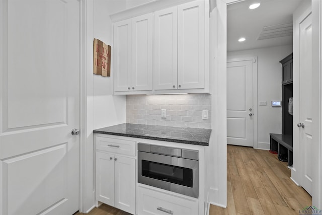 113 Saddle Brook Cir, Hallsville, TX 75650 - kitchen featuring dark stone countertops, decorative backsplash, light wood-style floors, white cabinetry, and recessed lighting
