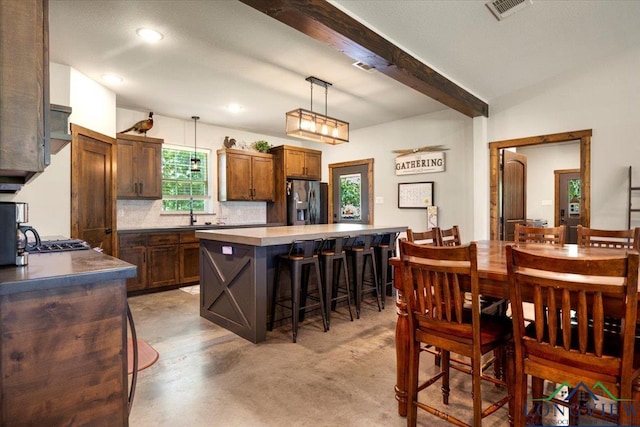 15136 Fm 852, Gilmer, TX 75644 - kitchen featuring refrigerator with ice dispenser, a kitchen bar, beam ceiling, a kitchen island, and decorative light fixtures