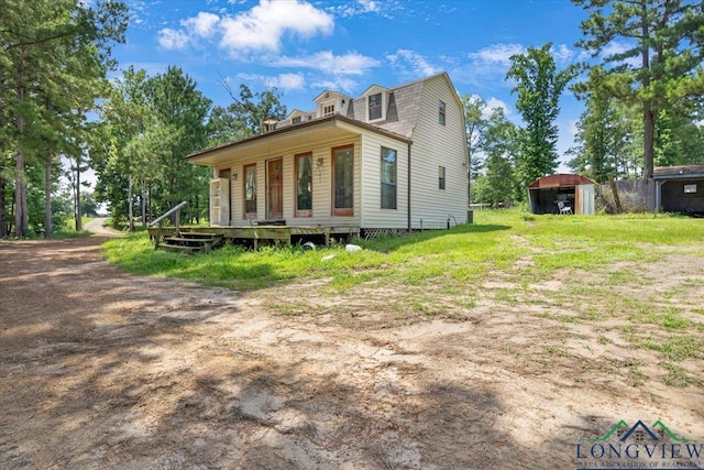 15136 Fm 852, Gilmer, TX 75644 - view of front facade with a gambrel roof, an outdoor structure, and a deck