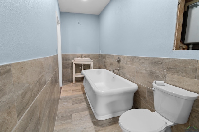 bathroom featuring sink, toilet, tile walls, water heater, and a tub