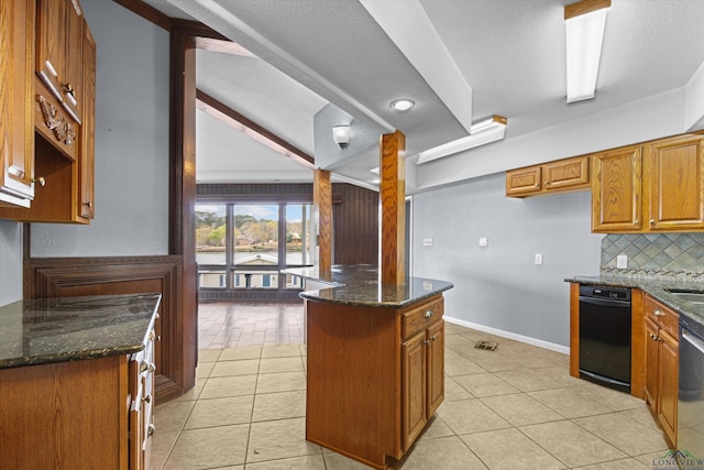 kitchen featuring light tile patterned floors, backsplash, a center island, and dark stone countertops