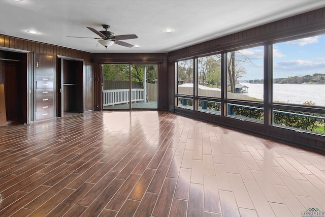 unfurnished sunroom featuring a water view and ceiling fan