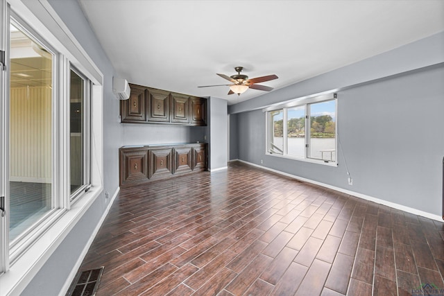 interior space with ceiling fan and a wall unit AC