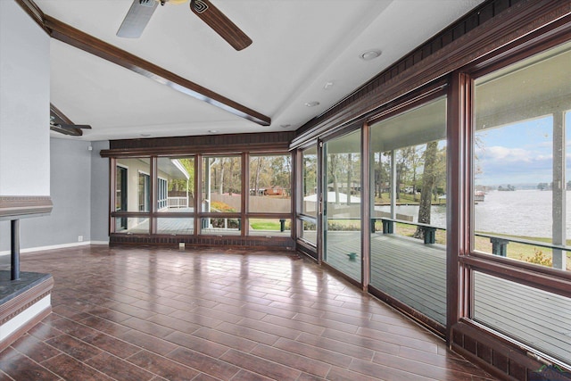 unfurnished sunroom with vaulted ceiling with beams, ceiling fan, and a water view