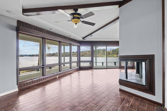 unfurnished sunroom featuring a wealth of natural light, lofted ceiling with beams, a water view, and ceiling fan