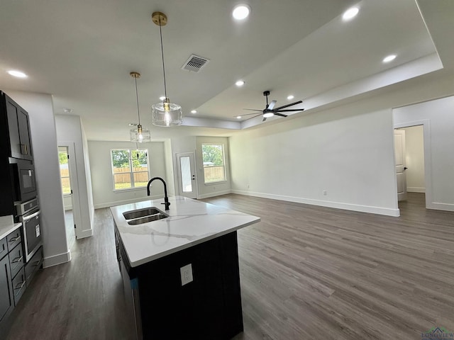 208 W Houston St, Daingerfield, TX 75638 - kitchen with a sink, a tray ceiling, oven, dark wood finished floors, and baseboards