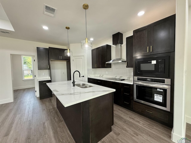208 W Houston St, Daingerfield, TX 75638 - kitchen featuring black appliances, a sink, wall chimney exhaust hood, tasteful backsplash, and wood finished floors