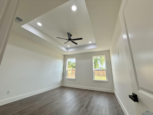 208 W Houston St, Daingerfield, TX 75638 - unfurnished room featuring dark wood finished floors, a tray ceiling, a ceiling fan, recessed lighting, and baseboards