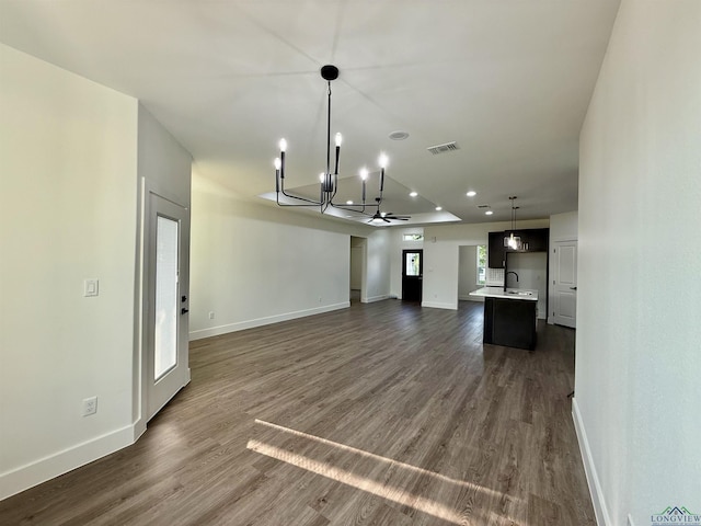 208 W Houston St, Daingerfield, TX 75638 - unfurnished living room featuring a chandelier, baseboards, dark wood-type flooring, and recessed lighting