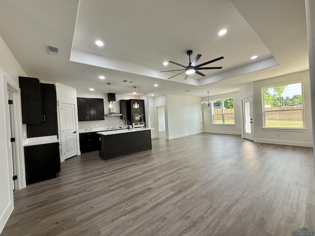 208 W Houston St, Daingerfield, TX 75638 - unfurnished living room featuring a tray ceiling, a ceiling fan, baseboards, dark wood-style floors, and recessed lighting