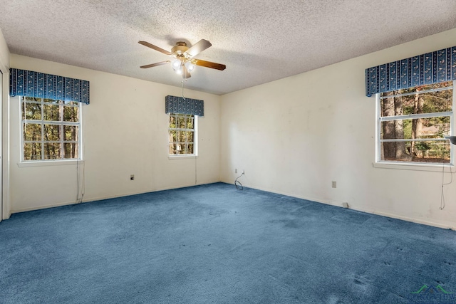 carpeted spare room featuring ceiling fan and a textured ceiling