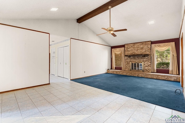 unfurnished living room with vaulted ceiling with beams, ceiling fan, a textured ceiling, and a brick fireplace