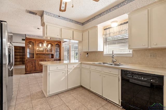 kitchen featuring sink, black dishwasher, kitchen peninsula, stainless steel fridge, and cream cabinets