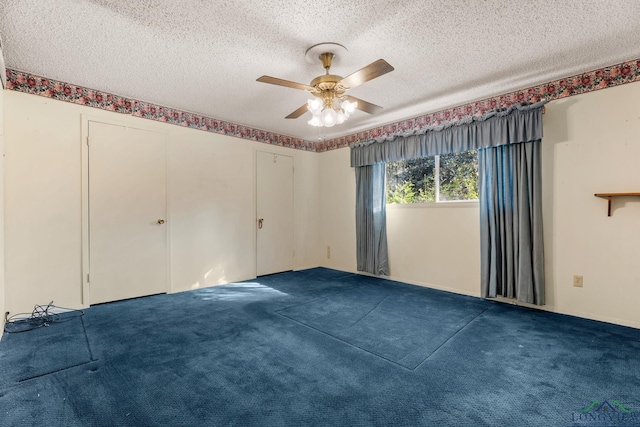 carpeted empty room featuring ceiling fan and a textured ceiling