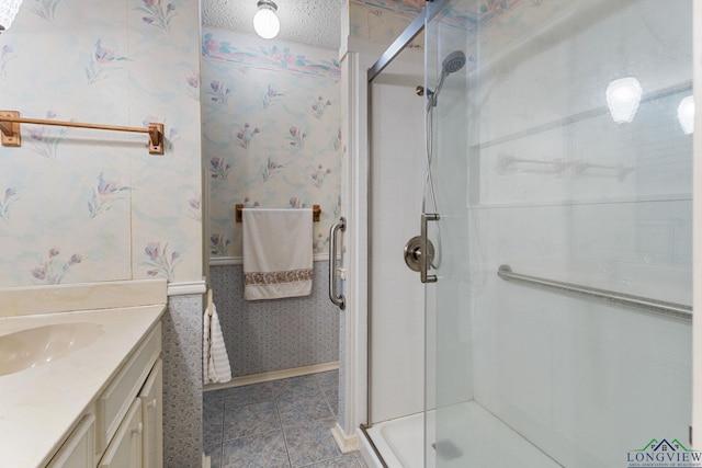 bathroom featuring vanity, a textured ceiling, and an enclosed shower