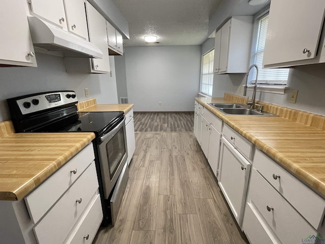 kitchen featuring a textured ceiling, sink, white cabinetry, and electric stove