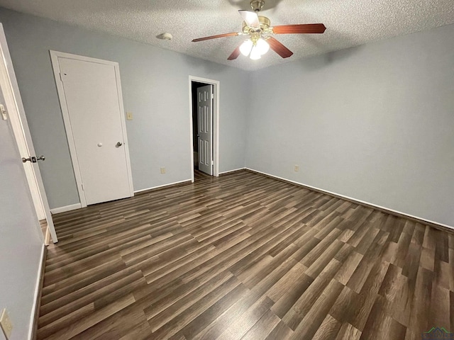 unfurnished bedroom featuring ceiling fan, dark hardwood / wood-style flooring, and a textured ceiling