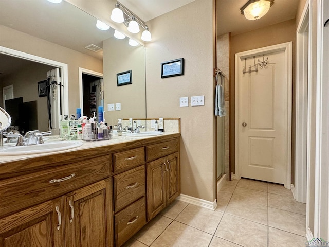 bathroom with tile patterned flooring, vanity, and walk in shower