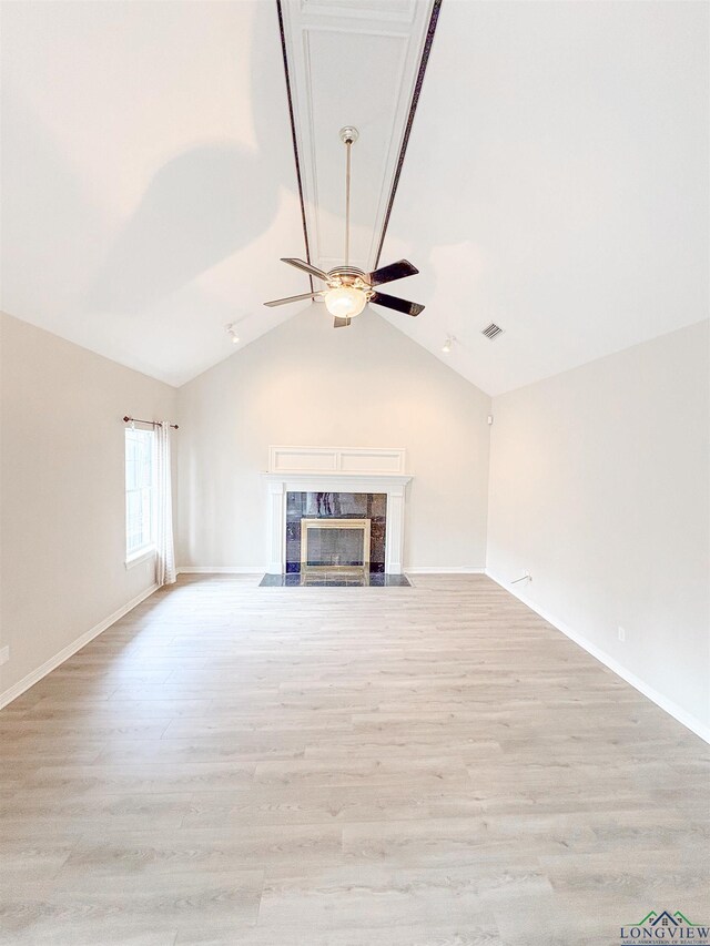unfurnished living room featuring visible vents, ceiling fan, vaulted ceiling, and light wood-type flooring