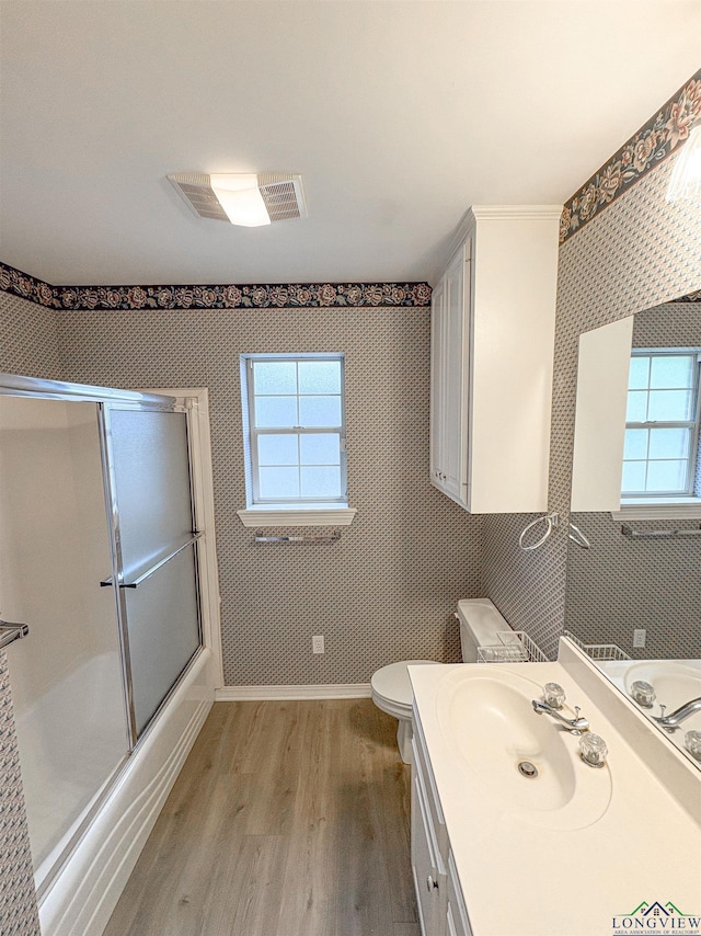 bathroom featuring wood finished floors, a wealth of natural light, toilet, and vanity