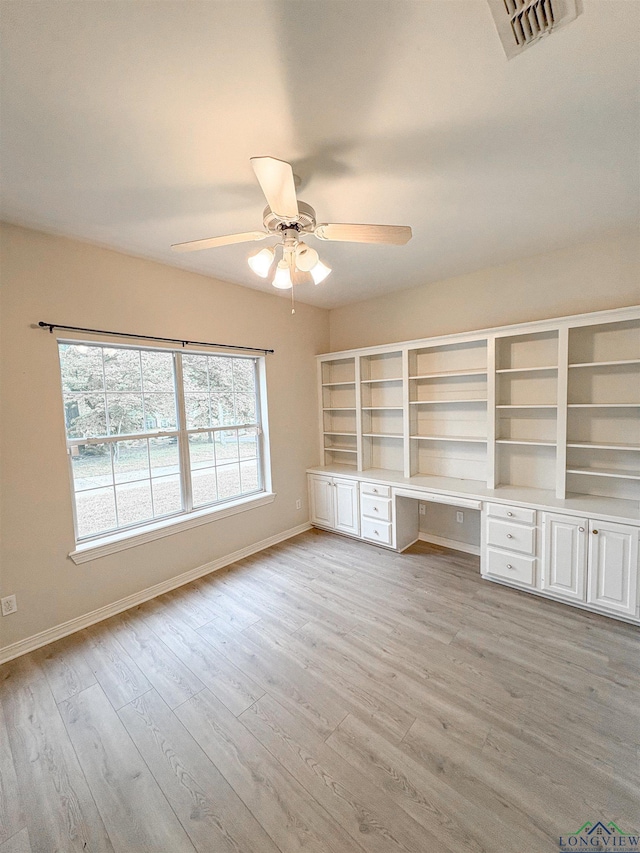 unfurnished office with baseboards, visible vents, a ceiling fan, and built in study area