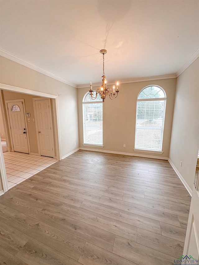 unfurnished dining area featuring crown molding, a notable chandelier, and a wealth of natural light