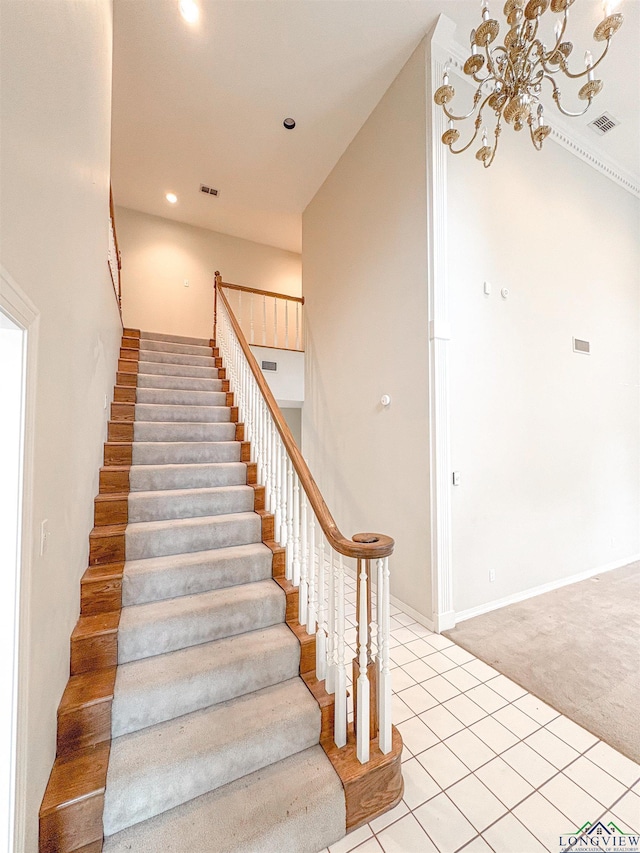 staircase with visible vents, an inviting chandelier, tile patterned flooring, and carpet flooring
