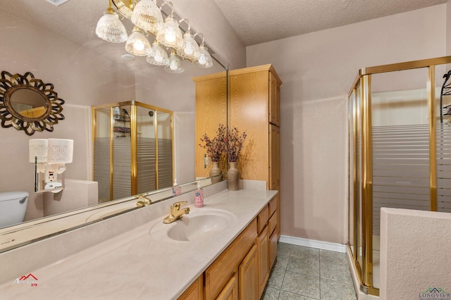 bathroom featuring vanity, toilet, an enclosed shower, and a textured ceiling