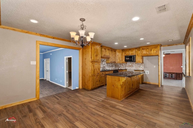 kitchen with dark hardwood / wood-style flooring, ornamental molding, a chandelier, a kitchen island, and hanging light fixtures