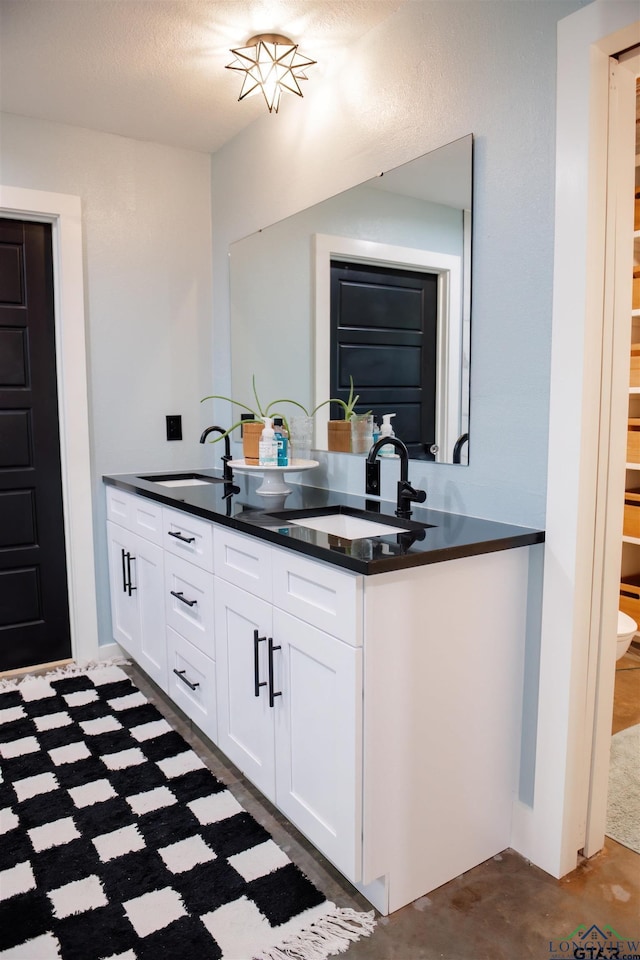 kitchen featuring kitchen peninsula, white cabinetry, and sink