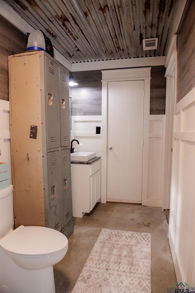 bathroom with vanity, concrete floors, and toilet