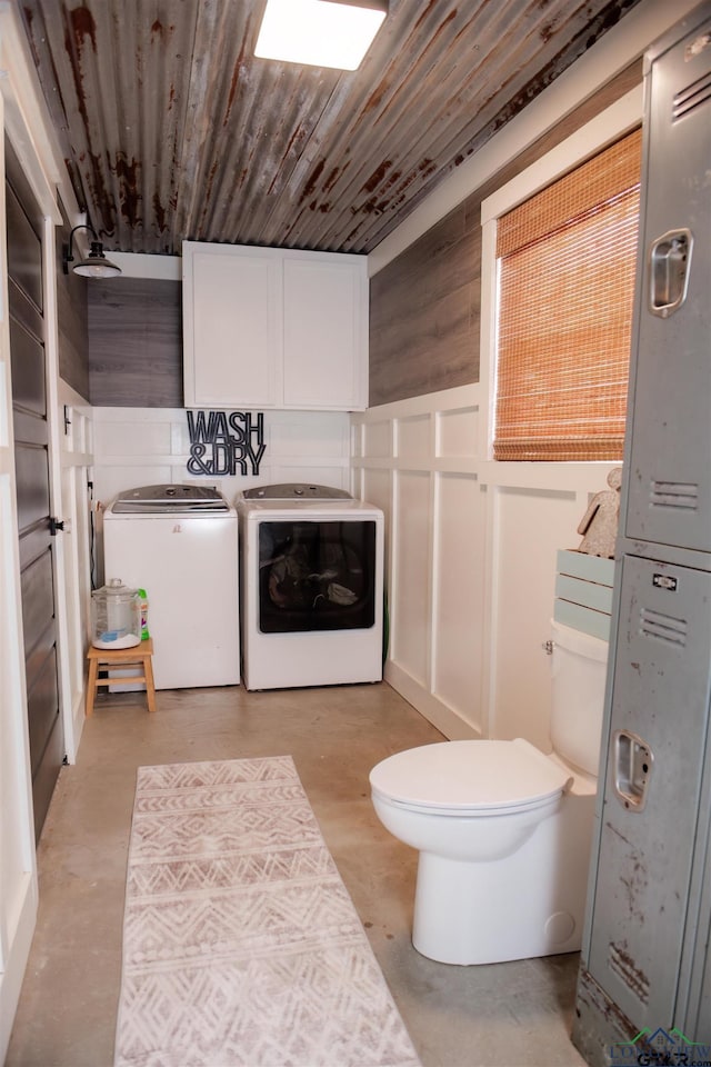 bathroom with washing machine and clothes dryer, wood ceiling, and toilet