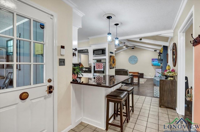 918 S Evenside St, Henderson, TX 75654 - kitchen with appliances with stainless steel finishes, light tile patterned floors, ornamental molding, baseboards, and a peninsula