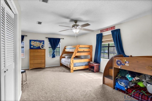 918 S Evenside St, Henderson, TX 75654 - carpeted bedroom with baseboards, a closet, a textured ceiling, and ceiling fan