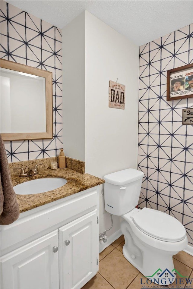 918 S Evenside St, Henderson, TX 75654 - bathroom featuring toilet, vanity, a textured ceiling, tile patterned floors, and baseboards