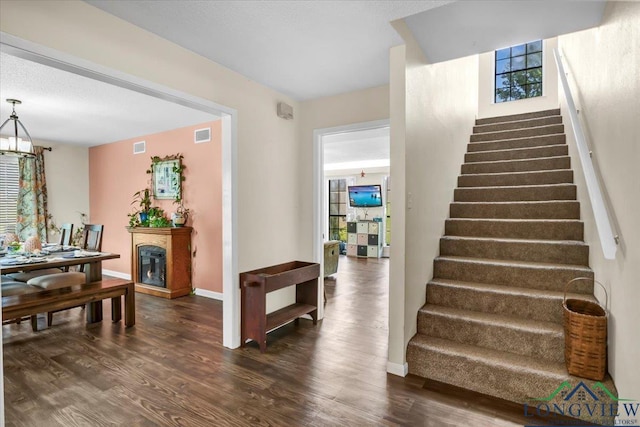918 S Evenside St, Henderson, TX 75654 - stairway with wood finished floors, baseboards, and a glass covered fireplace