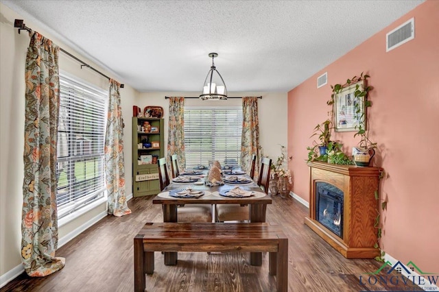 918 S Evenside St, Henderson, TX 75654 - dining area featuring a textured ceiling, wood finished floors, baseboards, and a glass covered fireplace