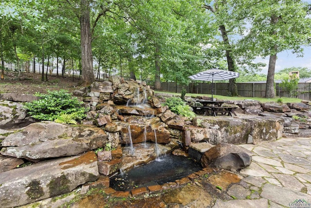 1307 Yates Dr, Longview, TX 75601 - fenced backyard with a garden pond and a patio
