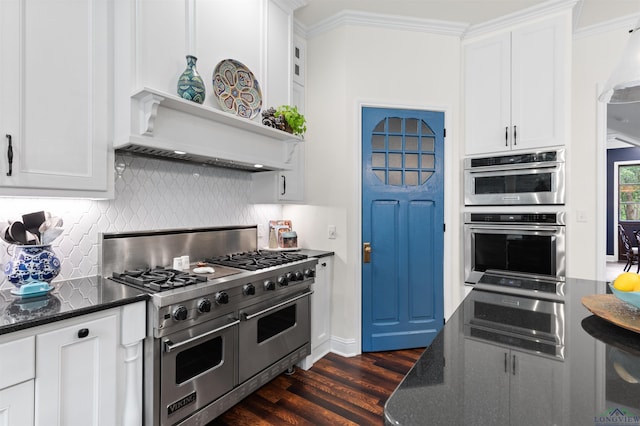 1307 Yates Dr, Longview, TX 75601 - kitchen with appliances with stainless steel finishes, dark wood-style flooring, white cabinets, decorative backsplash, and dark stone countertops