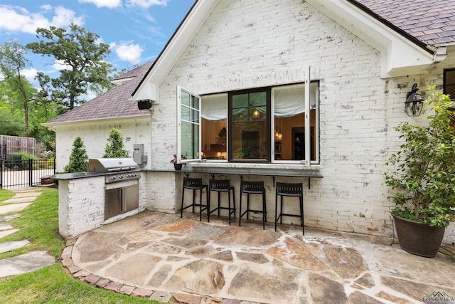 1307 Yates Dr, Longview, TX 75601 - view of patio featuring area for grilling, a grill, fence, and an outdoor bar