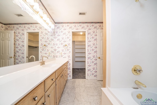 bathroom featuring vanity, a tub to relax in, and crown molding